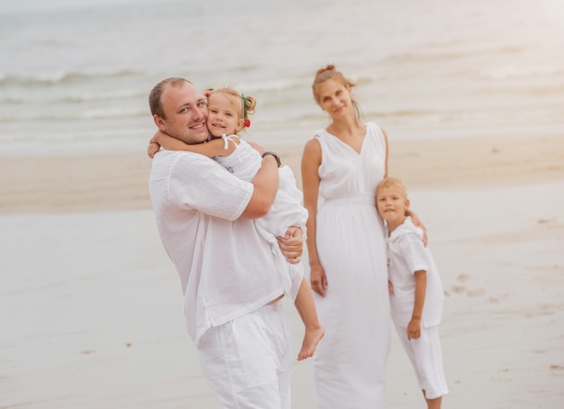 Happy young family on the sunset at the beach.