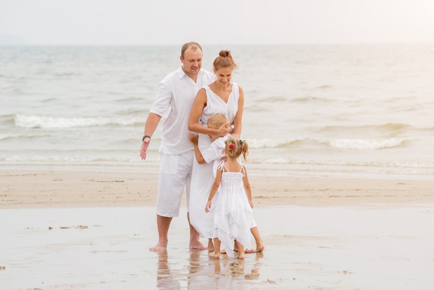 Happy young family on the sunset at the beach.