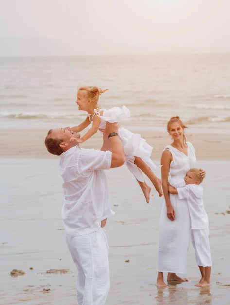 Happy young family on the sunset at the beach.