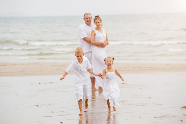 Happy young family on the sunset at the beach.