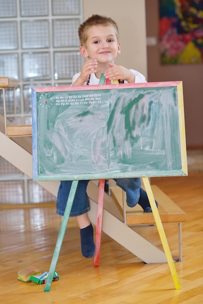 happy young family teach leassons and prepare their son for school while draw on board at home