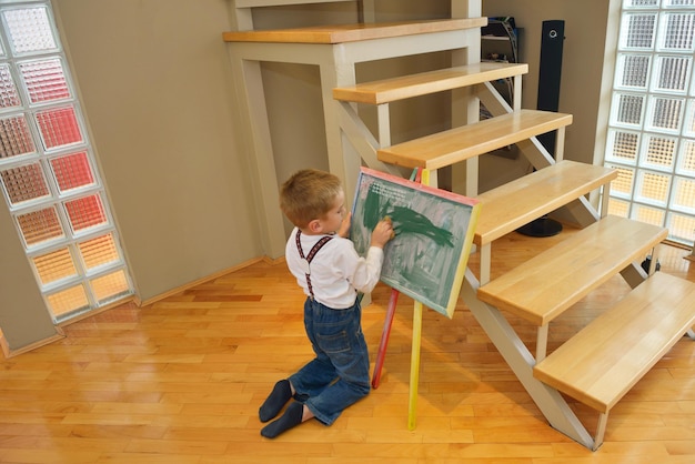 happy young family teach leassons and prepare their son for school while draw on board at home