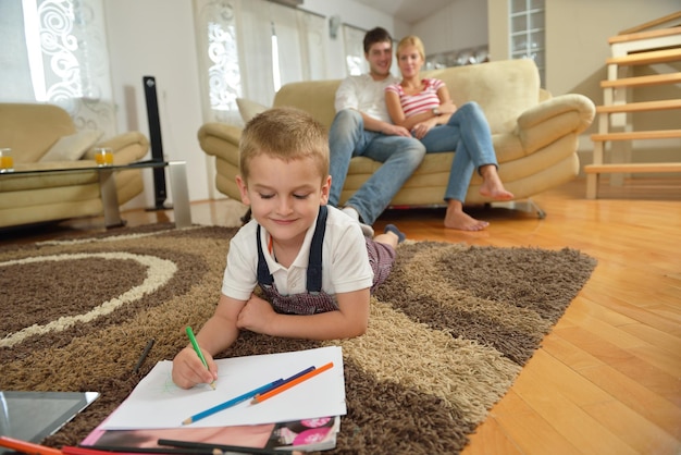 happy young family teach leassons and prepare their son for school while draw on board at home