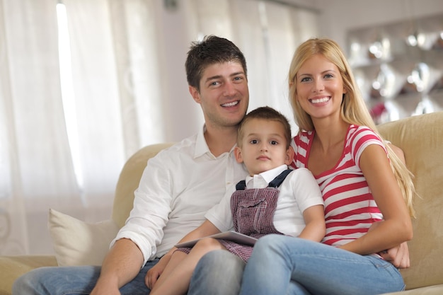 happy young family using tablet computer at modern  home for playing games and education