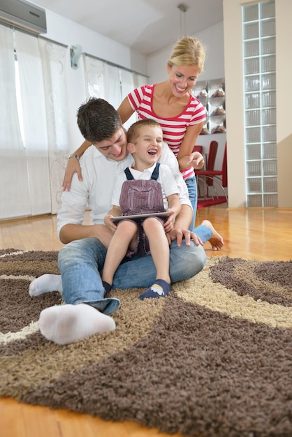 happy young family using tablet computer at modern  home for playing games and education