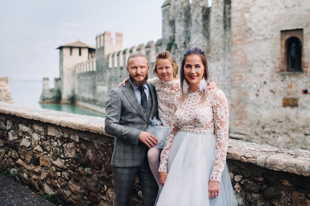 A happy young family walks through the old town of Sirmione in Italy.Stylish family in Italy on a walk.