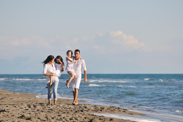 happy young family in white clothing have fun at vacations on beautiful beach