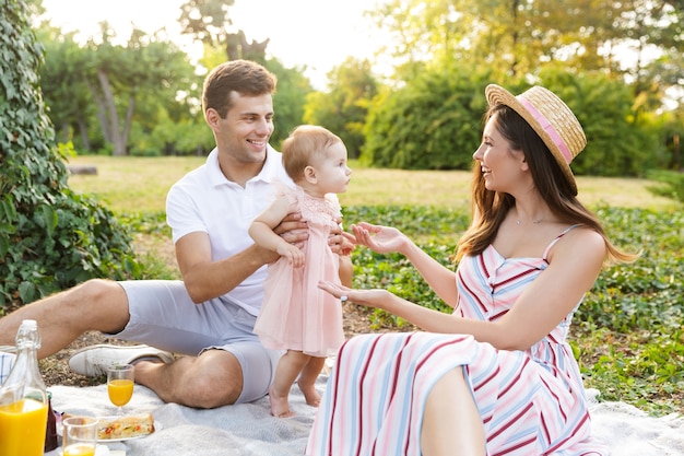 Happy young family with little baby girl spending time together