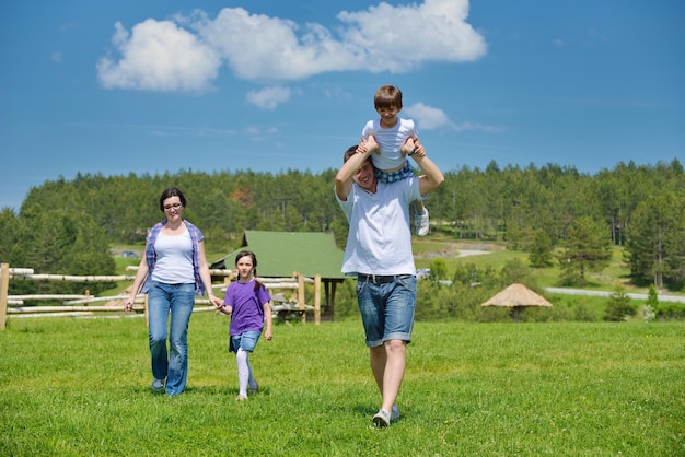 happy young family with their kids have fun and relax outdoors in nature with blue sky in background