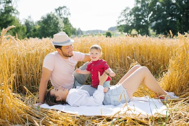 Happy young family with a young son have fun in the summer in the field