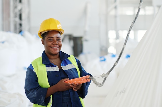 Happy young female engineer of factory using switch remote control