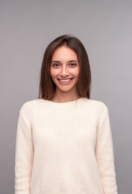 Happy young female in knitted sweater friendly smiling