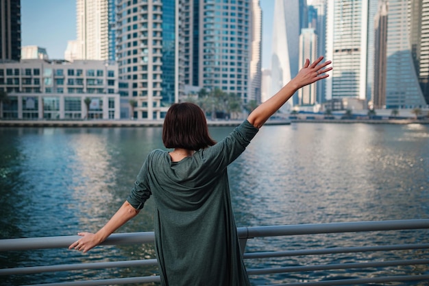 Photo happy young female traveler in the big city of dubai uae