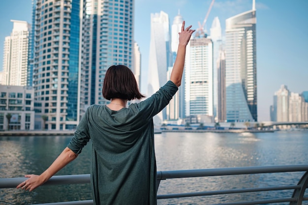 Happy young female traveler in the big city of Dubai UAE