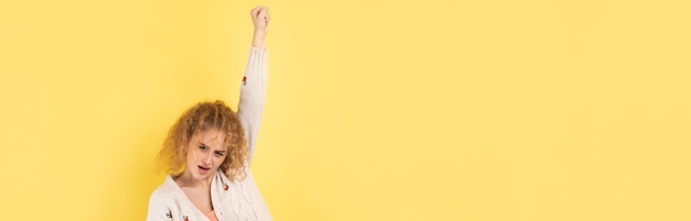 Happy young girl raises her fist up in delight Successful victory gestures