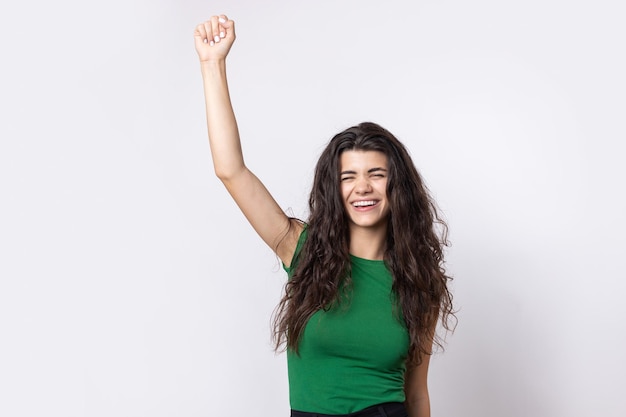 Happy young girl raises her fist up in delight Successful victory gestures