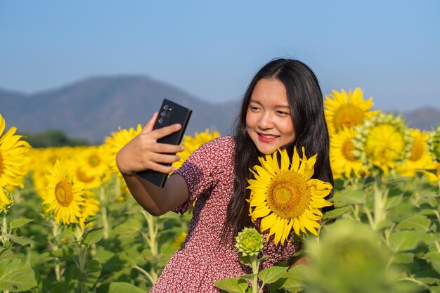 Happy young girl selfie with beautiful sunflower and blue sky