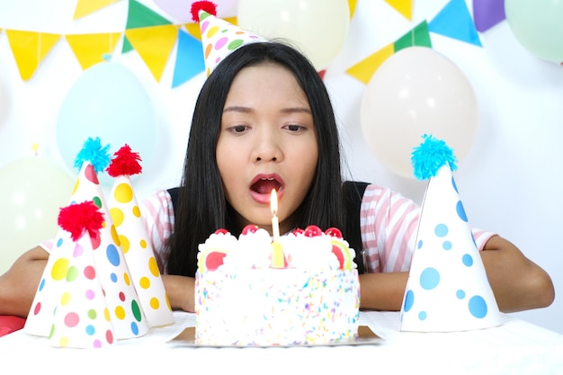 Happy young girl with cake on birthday party on white background.