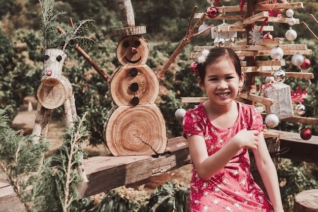 Happy  young girl with Christmas festive decoration made from reusable wood