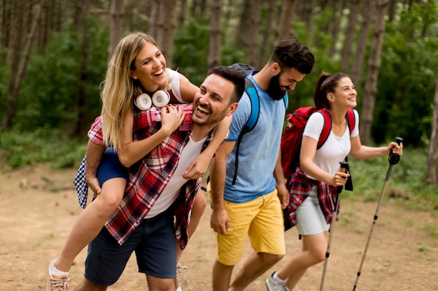 Happy young group hiking together through the forest