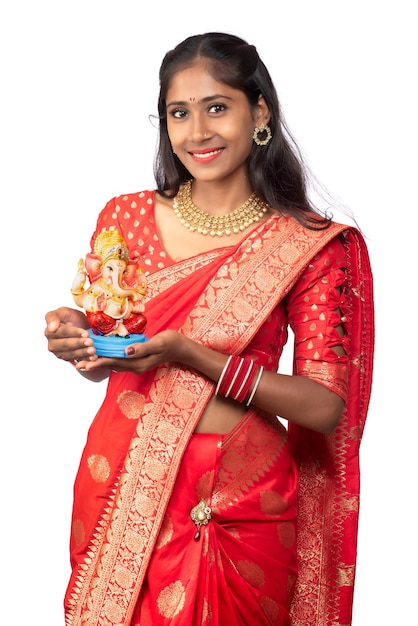 Happy young Indian girl posing with Ganesha statue on the occasion of Ganesh Festival