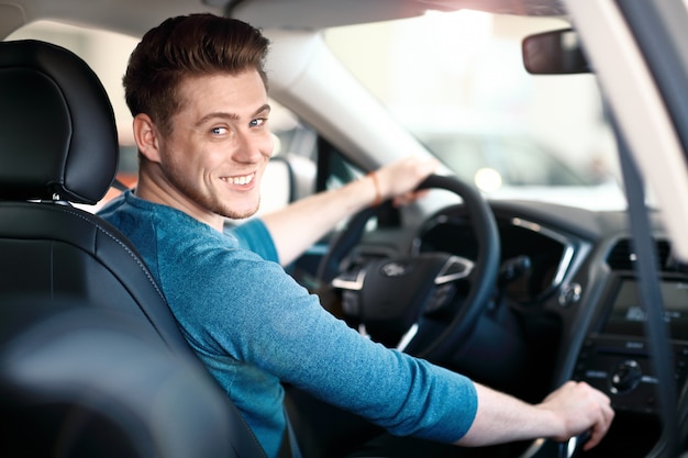 Happy young male driver behind the wheel