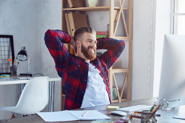 Happy young man having break in his office