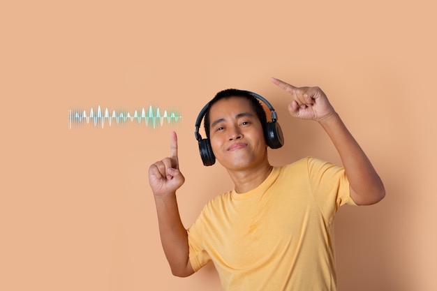 Happy young man in headphones listening to music and dancing with sound waves