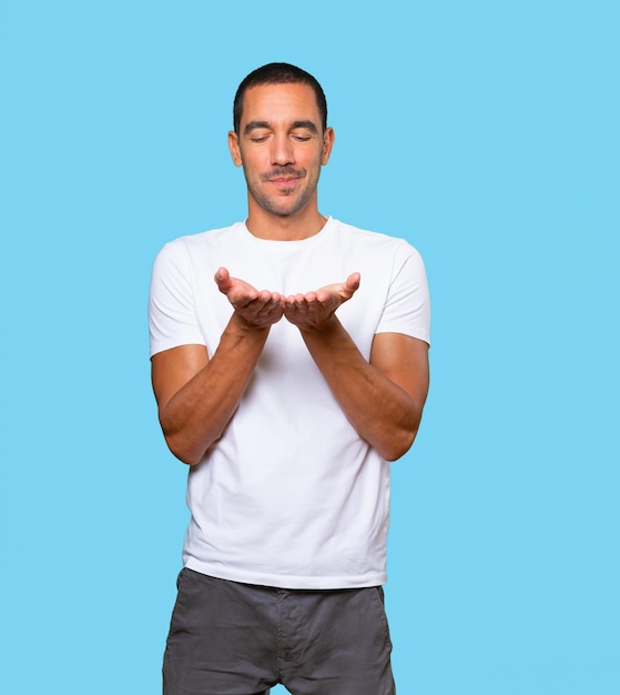 Happy young man holding something with his hand