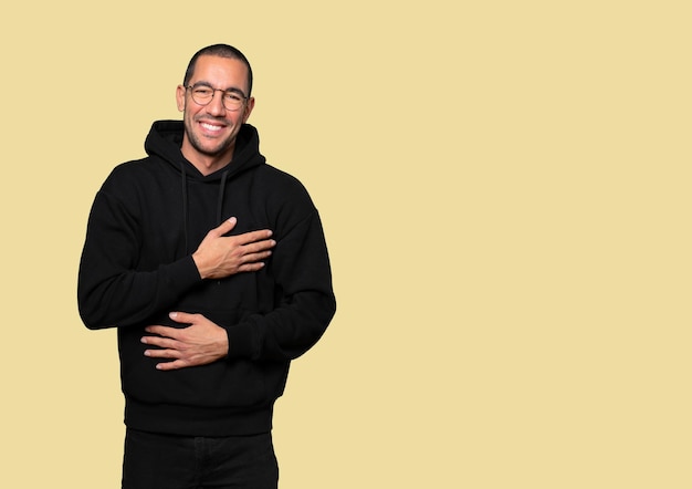 Happy young man laughing against background