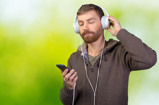 Happy young man listening to music with headphones