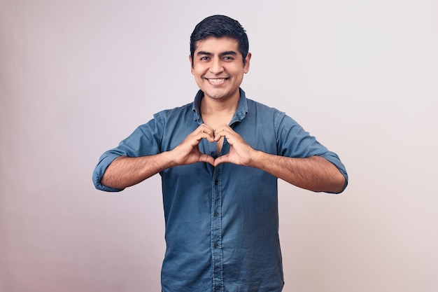 Happy young man makes love gestures with his hands Model isolated on white background