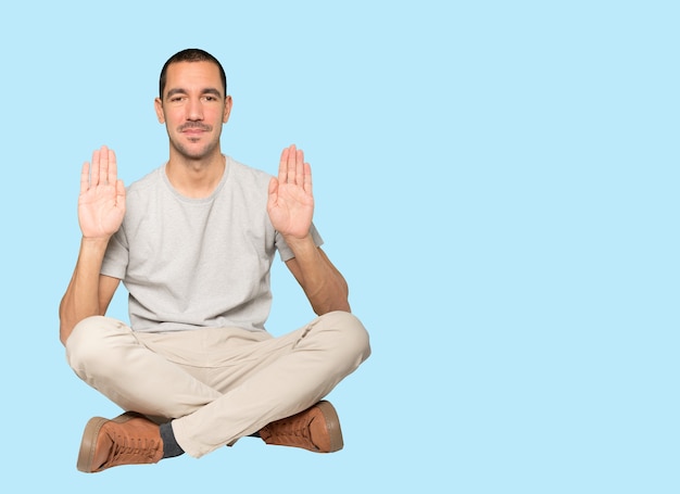 Happy young man making a gesture of stop with his palm