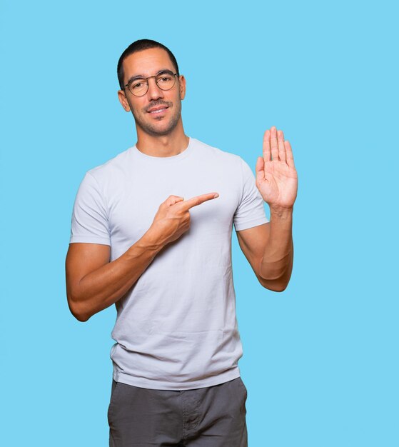 Happy young man making a gesture of stop with his palm