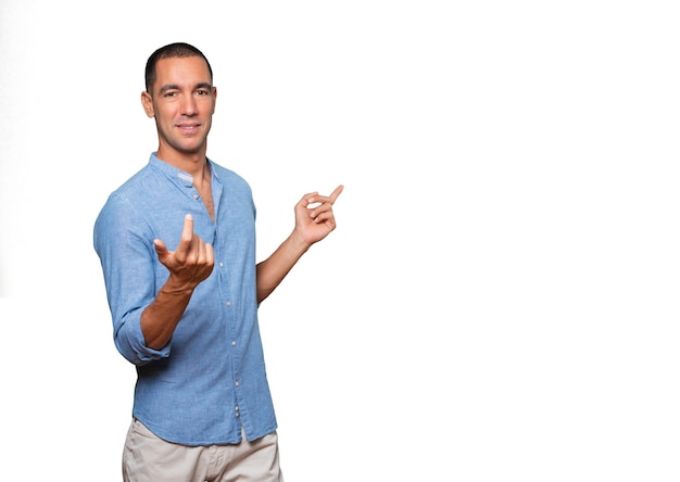 Happy young man making a welcome gesture with his hand