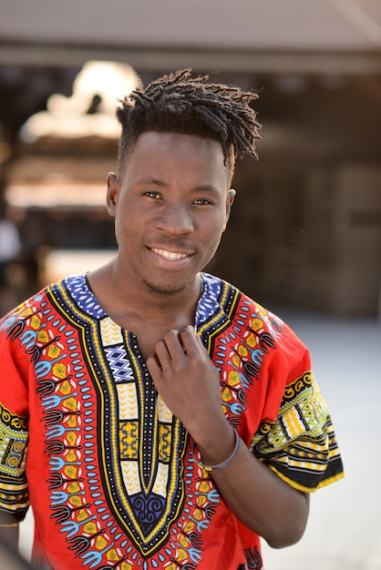 Happy young man in Nigerian national clothes outdoors