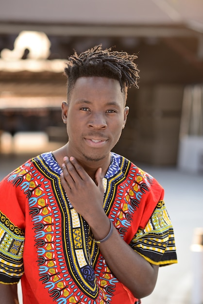 Happy young man in Nigerian national clothes outdoors