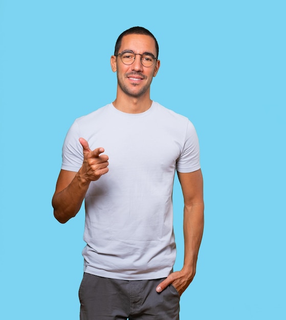 Happy young man pointing at you with his finger