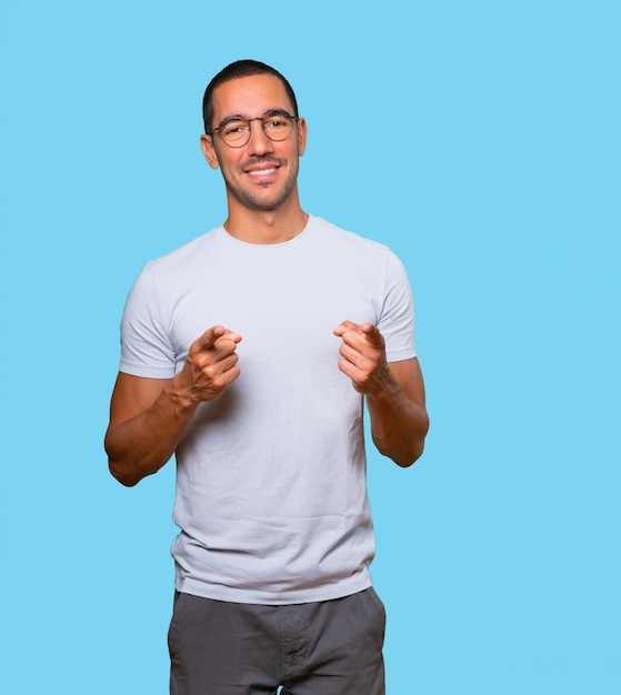 Happy young man pointing at you with his finger