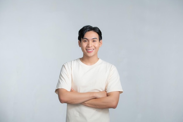 Happy young man posing with hands folded on a white background