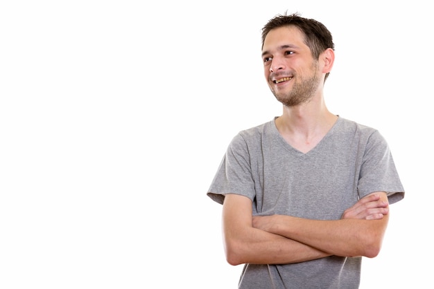 happy young man smiling and thinking with arms crossed