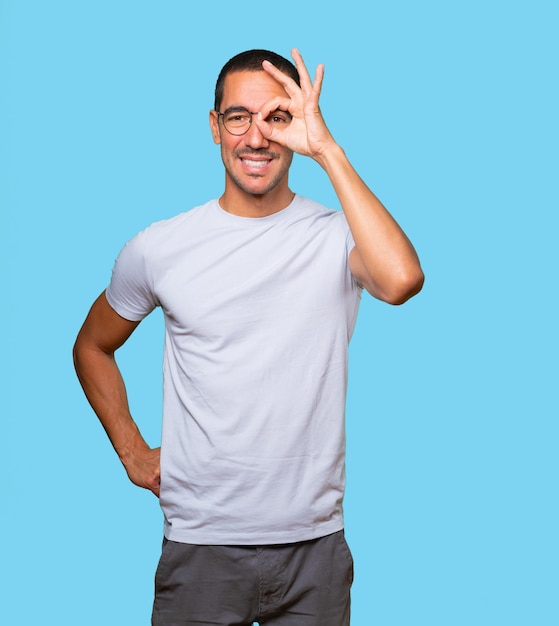 Happy young man using his hands like a binoculars