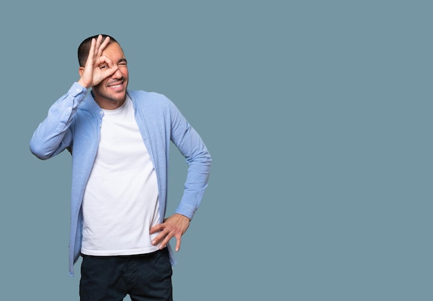 Happy young man using his hands like a binoculars