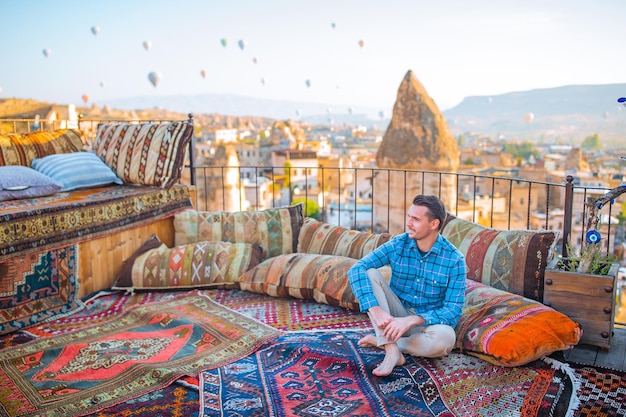 Happy young man watching hot air balloons in cappadocia turkey