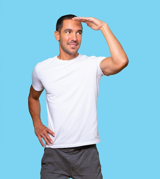 Happy young man with a gesture of looking away