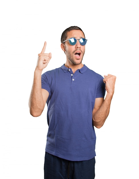 Happy young man with number one gesture on white background