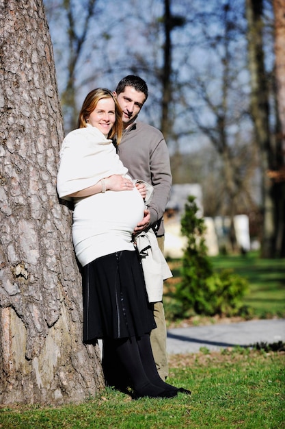 Photo happy young married family couple outdoor in nature have fun and waiting baby and representing young family growth and pregnancy concept