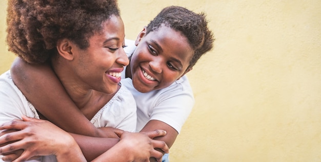 Happy young mother having fun with her kid - Son hugging his mum outdoor - Family connection, motherhood, love and tender moments concept - Focus on boy face