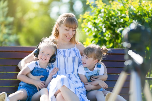 Happy young mother with children in front of a video camera.