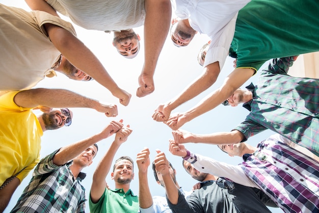 Photo happy young people in circle with thumb up